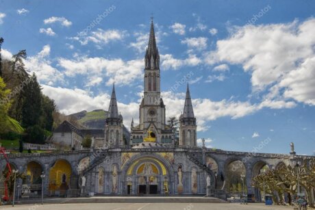 Pellegrini in preghiera al Santuario di Lourdes al tramonto